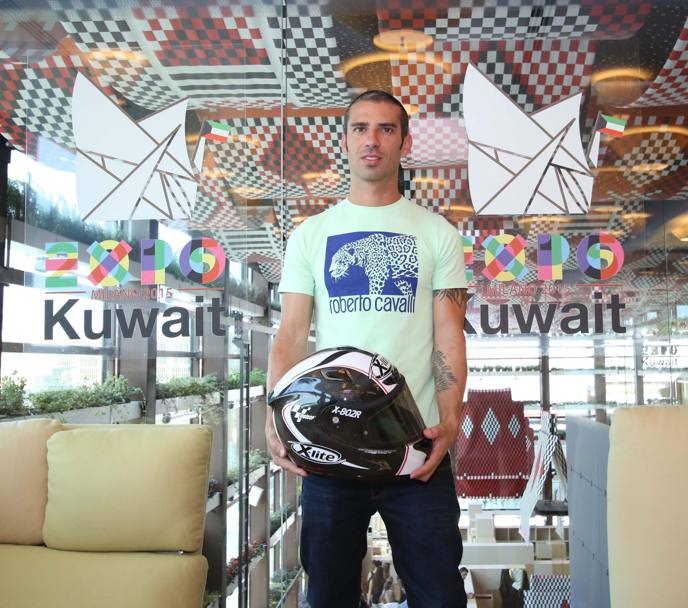Il pilota, con maglietta griffata Roberto Cavalli, posa al padiglione del Kuwait (Ansa)